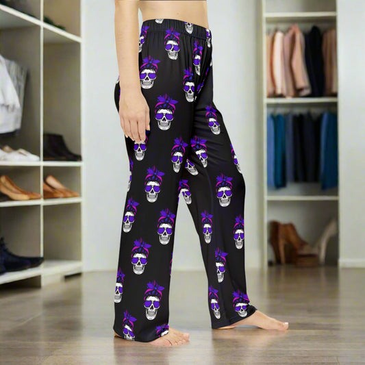 Black pajama pants with skull and bow pattern on a white background