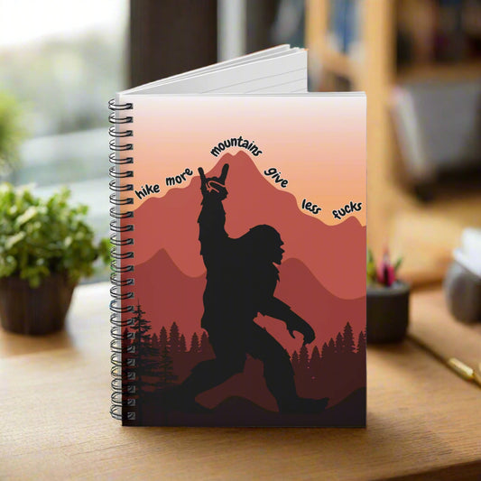 Notebook with a Bigfoot design and mountain text on a red background